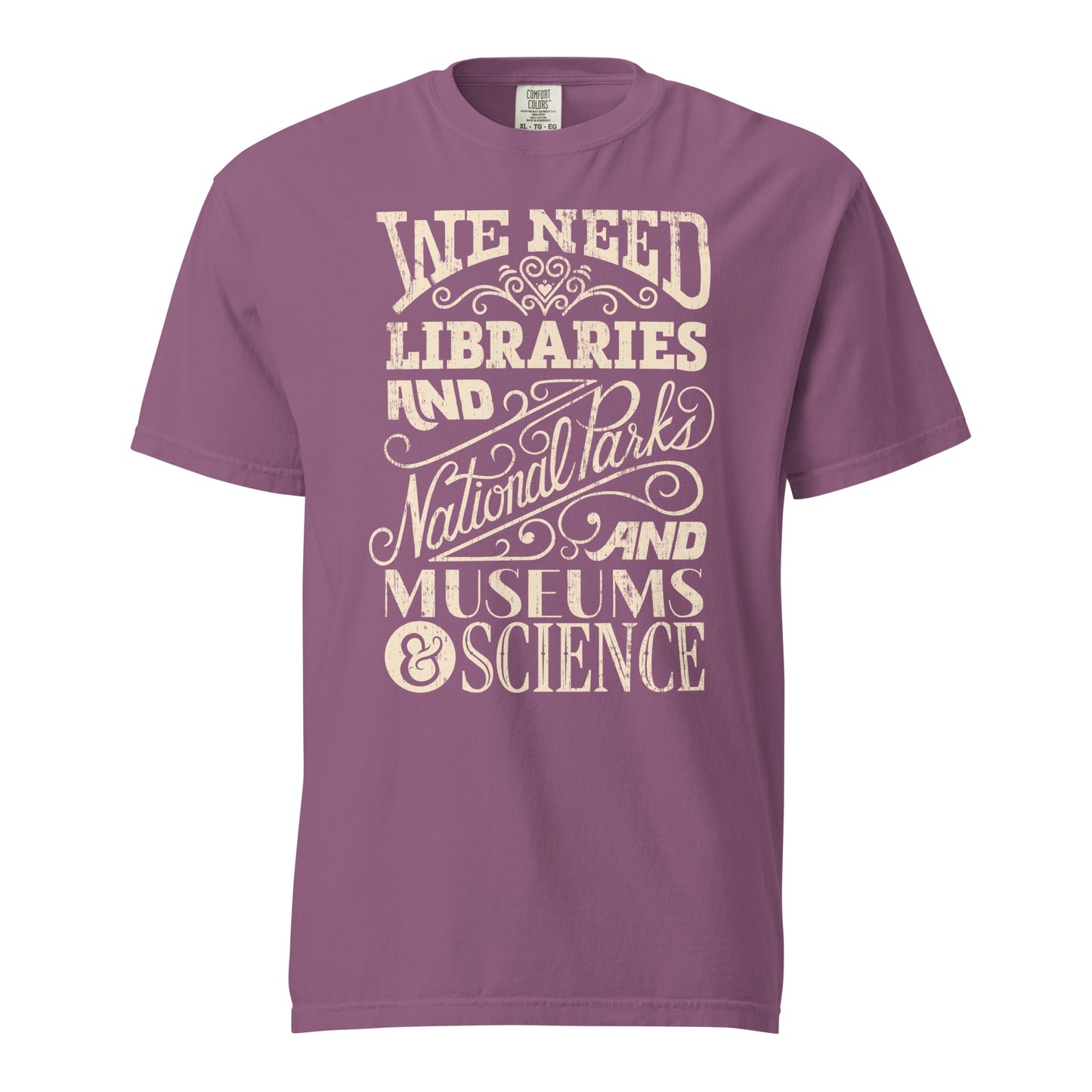 Berry Purple Pink Red Comfort Colors t-shirt with a hand lettered typography design reading "We Need Libraries and National Parks and Museums and Science."