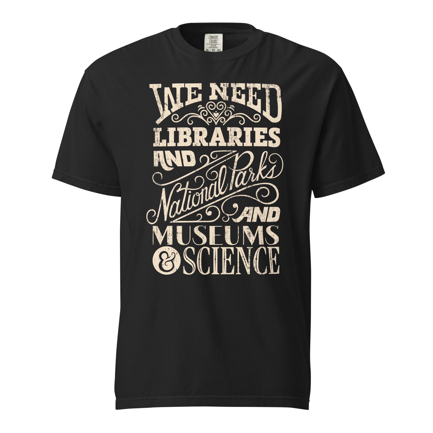 Black Comfort Colors t-shirt with a hand lettered typography design reading "We Need Libraries and National Parks and Museums and Science."