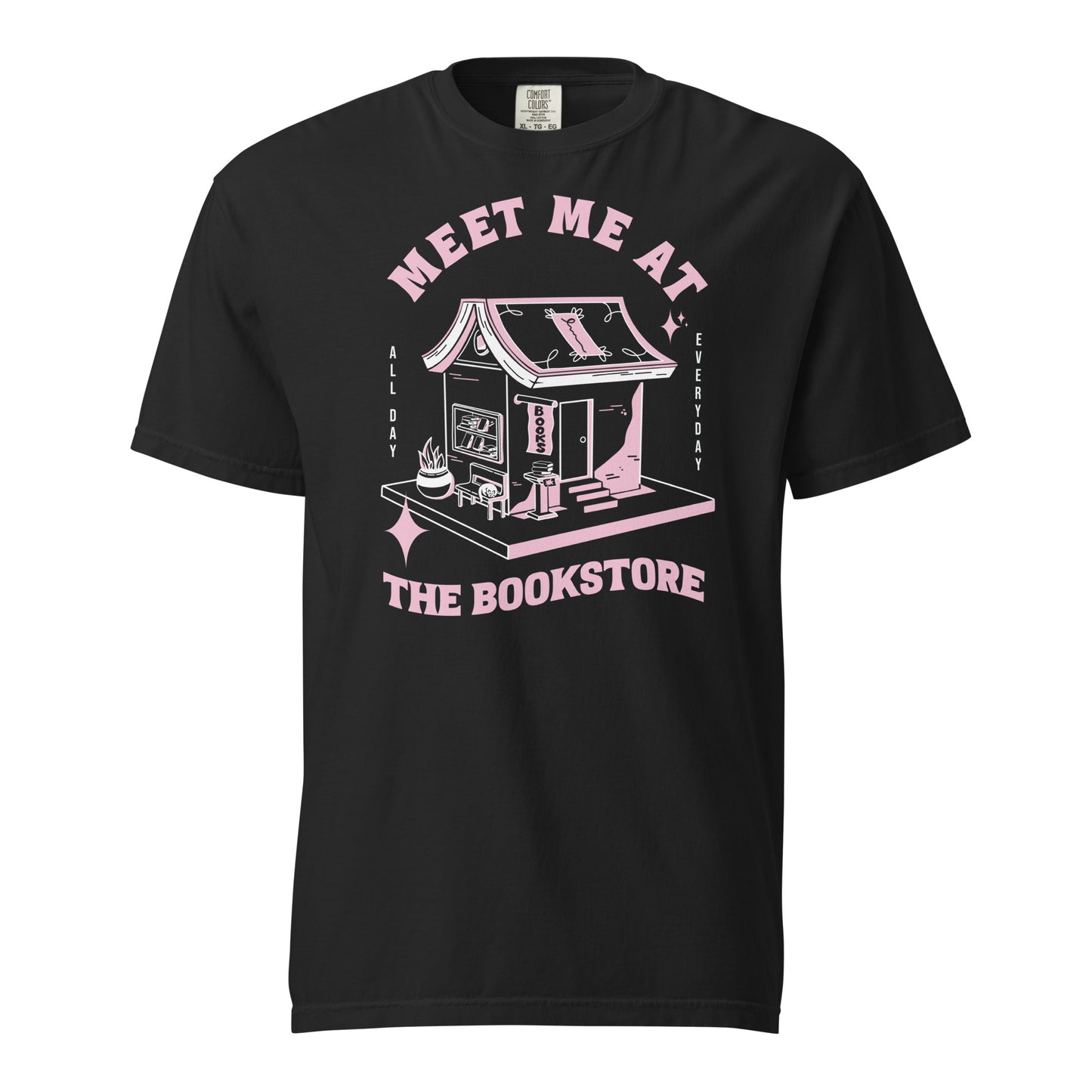 Black Comfort Colors t-shirt with a hand-drawn design of a bookstore with a cute cat on a bench and books in the window, and an open book as a roof, with the text "Meet me at the Bookstore", Vertical text on either side reads all day, and everyday.