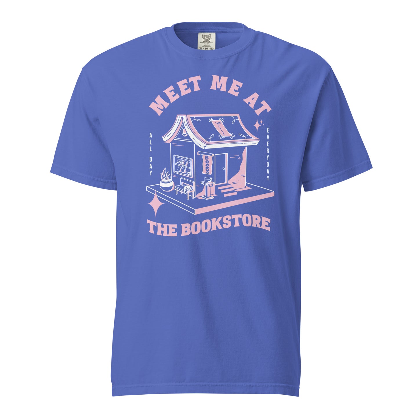 Flo Blue Comfort Colors t-shirt with a hand-drawn design of a bookstore with a cute cat on a bench and books in the window, and an open book as a roof, with the text "Meet me at the Bookstore", Vertical text on either side reads all day, and everyday.