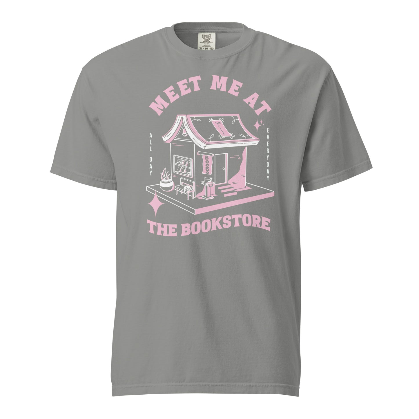Gray Comfort Colors t-shirt with a hand-drawn design of a bookstore with a cute cat on a bench and books in the window, and an open book as a roof, with the text "Meet me at the Bookstore", Vertical text on either side reads all day, and everyday.