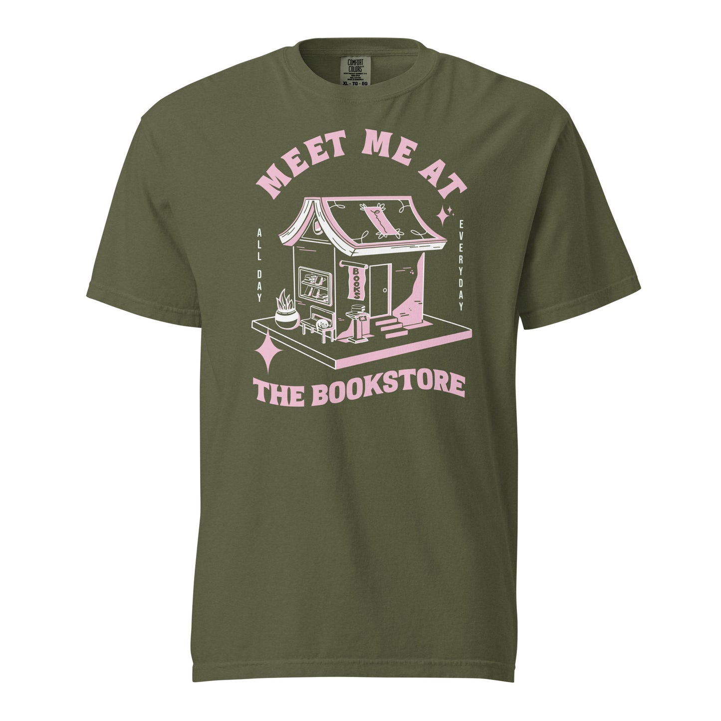Hemp Comfort Colors t-shirt with a hand-drawn design of a bookstore with a cute cat on a bench and books in the window, and an open book as a roof, with the text "Meet me at the Bookstore", Vertical text on either side reads all day, and everyday.