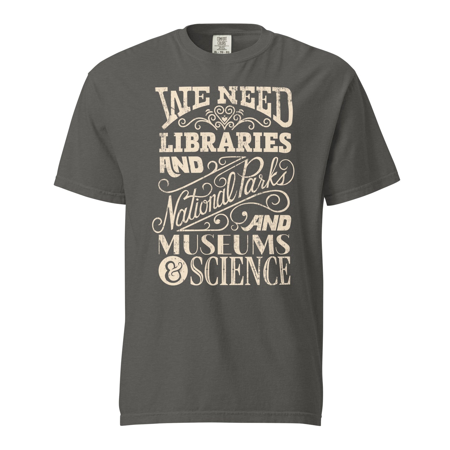 Pepper Gray Comfort Colors t-shirt with a hand lettered typography design reading "We Need Libraries and National Parks and Museums and Science."