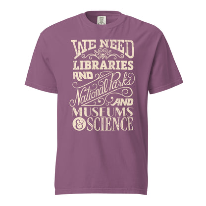 Berry Purple Pink Red Comfort Colors t-shirt with a hand lettered typography design reading "We Need Libraries and National Parks and Museums and Science."